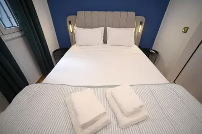 a bedroom with a bed with two towels on it at Monastiraki Suite by Zeussuites in Athens