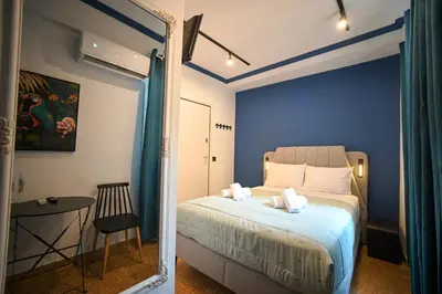 a bedroom with blue walls and a bed with a mirror at Ermou Suite by Zeussuites in Athens