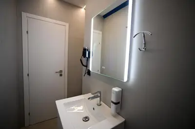 a bathroom with a white sink and a mirror at Ermou Suite by Zeussuites in Athens