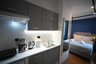 a small kitchen with a sink and a bed at Ermou Suite by Zeussuites in Athens