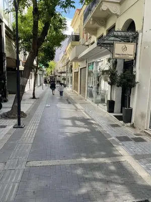 an empty street with people walking down the street at Ermou Suite by Zeussuites in Athens