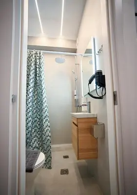 a bathroom with a toilet and a shower curtain at Athinaidos Suite by Zeussuites in Athens