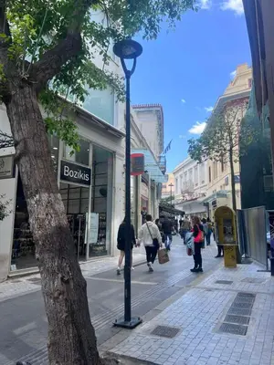 a street light on a city street with people walking down the street at Athinaidos Suite by Zeussuites in Athens