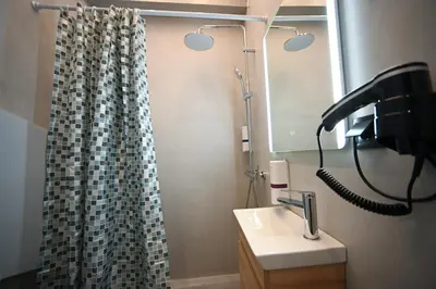 a bathroom with a sink and a shower curtain at Athinaidos Suite by Zeussuites in Athens
