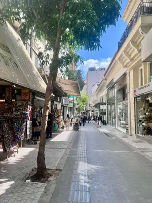 a street with a tree in the middle of a city at Athinaidos Suite by Zeussuites in Athens