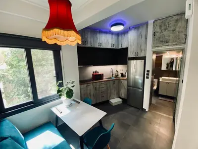 a kitchen with a white table and blue chairs at Sophia Urban lux in Athens