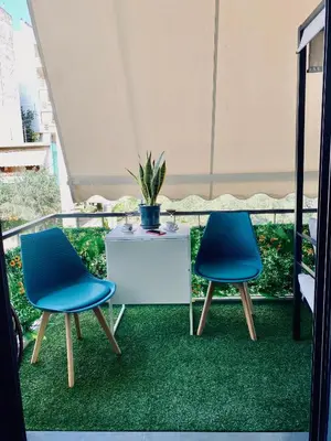 two chairs and a table with a potted plant on a balcony at Sophia Urban lux in Athens
