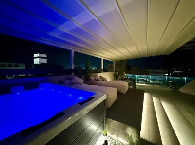 a living room with a couch and a swimming pool at BlueMotion - CityView in Piraeus