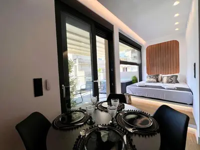 a room with a table with chairs and a bed at BlueMotion - PortSuite 4B in Piraeus