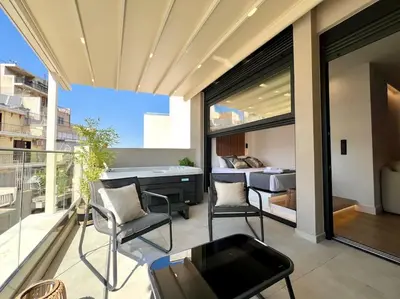 a balcony with chairs and a bed in a bedroom at BlueMotion - PortSuite 4B in Piraeus