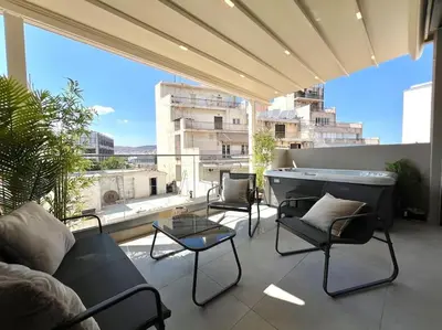 a patio with chairs and a tub on a balcony at BlueMotion - PortSuite 4B in Piraeus