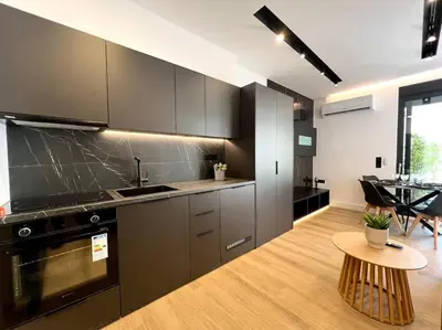 a kitchen with gray cabinets and a table in a room at BlueMotion - PortSuite 4B in Piraeus