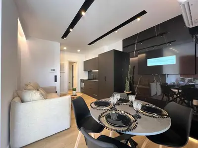 a living room with a table and chairs and a kitchen at BlueMotion - PortSuite 4B in Piraeus