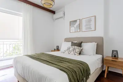 a white bedroom with a large bed and a window at Alimos 2BR Apartment with Splendid Sea View by UPSTREET in Athens