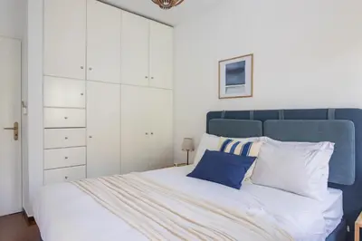a bedroom with a large bed with a blue headboard at Alimos 2BR Apartment with Splendid Sea View by UPSTREET in Athens