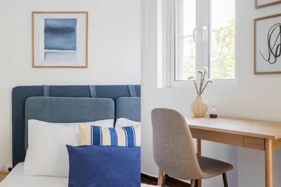 a desk and a chair next to a table with pillows at Alimos 2BR Apartment with Splendid Sea View by UPSTREET in Athens