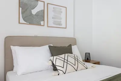 a bedroom with a white bed with two pictures on the wall at Alimos 2BR Apartment with Splendid Sea View by UPSTREET in Athens