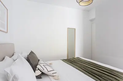 a bedroom with a bed with white sheets and pillows at Alimos 2BR Apartment with Splendid Sea View by UPSTREET in Athens