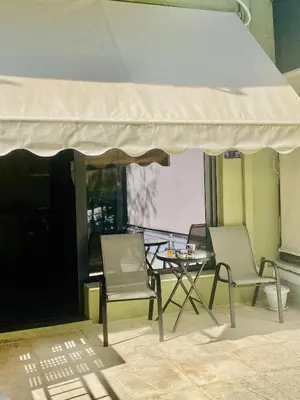 two chairs and a table under a white umbrella at Sophia Luxury Loft in Athens