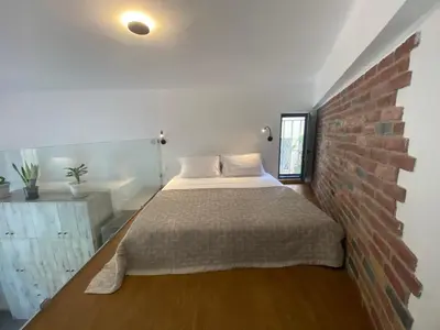 a bedroom with a bed against a brick wall at Sophia Luxury Loft in Athens