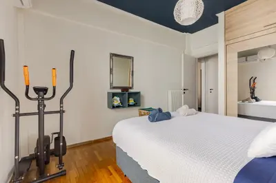 a bedroom with a large white bed and a mirror at Lina's Home in Athens