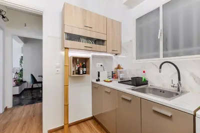 a kitchen with wooden cabinets and a sink at Lina's Home in Athens