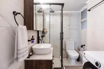 a white bathroom with a toilet and a sink at Lina's Home in Athens