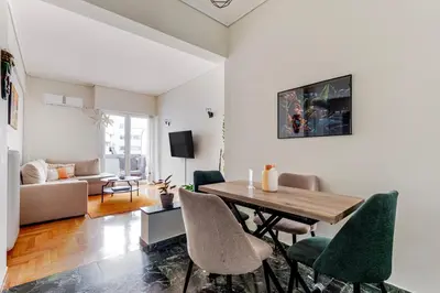 a living room with a dining room table and chairs at Lina's Home in Athens