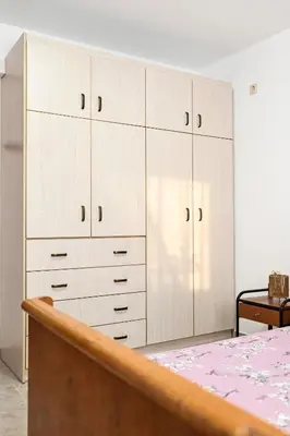 a bedroom with white cabinets and a bed at morfo's sunset in Sounio