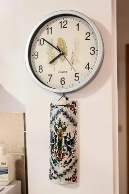 a clock hanging on a wall with a rag at morfo's sunset in Sounio