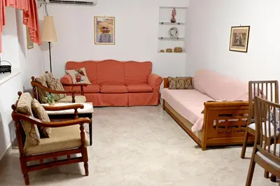 a living room with a couch and a table at morfo's sunset in Sounio