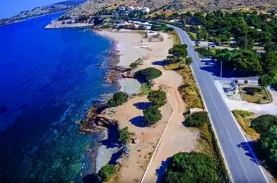 an aerial view of the shoreline of a beach at morfo's sunset in Sounio