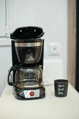 a coffee maker sitting on a counter next to a cup at Marine Cocoon & Terrace Modern Apt, Private Garden in Athens