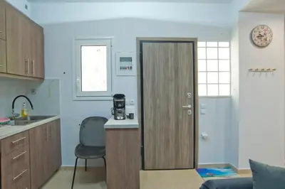 a kitchen with a door leading into a room at Marine Cocoon & Terrace Modern Apt, Private Garden in Athens