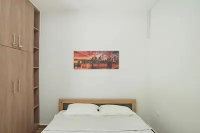 a bedroom with a bed and a painting on the wall at Marine Cocoon & Terrace Modern Apt, Private Garden in Athens