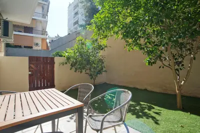 a table and chairs and a tree in a yard at Marine Cocoon & Terrace Modern Apt, Private Garden in Athens