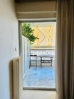 a view of a balcony with a table from a window at Mamour Apartments, Near Tram & 8' to Beach, Queen Bed Comfort in Athens