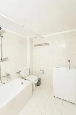 a white bathroom with a toilet and a bath tub at Mamour Apartments, Near Tram & 8' to Beach, Queen Bed Comfort in Athens