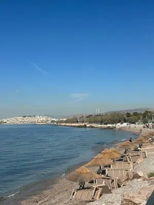 a beach with chairs and umbrellas and the water at Mamour Apartments, Near Tram & 8' to Beach, Queen Bed Comfort in Athens