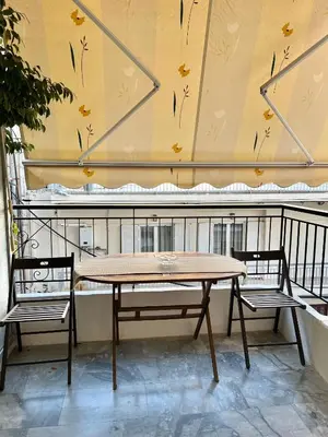 a table and two chairs on a balcony at Mamour Apartments, Near Tram & 8' to Beach, Queen Bed Comfort in Athens