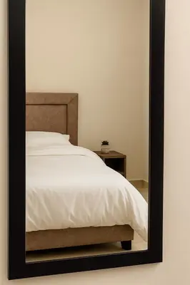 a mirror reflecting a bed in a bedroom at Mamour Apartments, Near Tram & 8' to Beach, Queen Bed Comfort in Athens