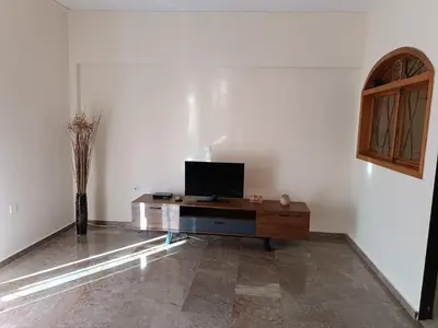 a living room with a television on a wooden table at ALΚO central PARK ATHENS in Athens