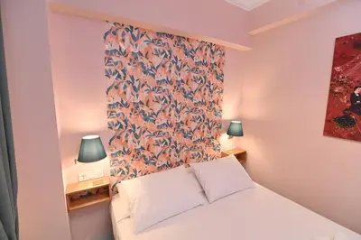 a bedroom with a white bed with a floral headboard at Warm & cozy studio - apartment 2 in Athens