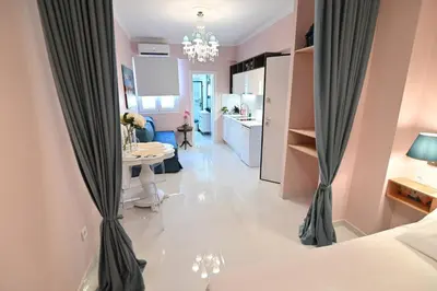 a room with pink walls and a white floor with curtains at Warm & cozy studio - apartment 2 in Athens