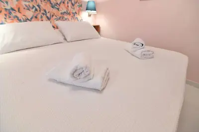 a white bed with towels on top of it at Warm & cozy studio - apartment 2 in Athens
