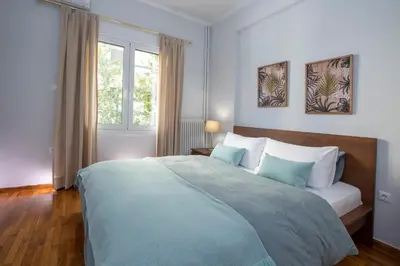 a bedroom with a large bed and a window at Apollon Apartment and Museum Acropolis in Athens