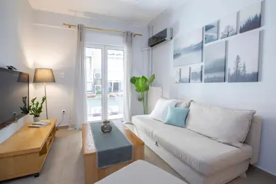 a living room with a white couch and a table at Apollon Apartment and Museum Acropolis in Athens