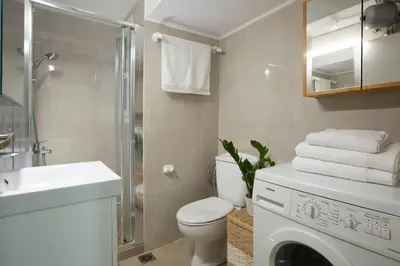 a bathroom with a toilet and a sink and a washing machine at Apollon Apartment and Museum Acropolis in Athens
