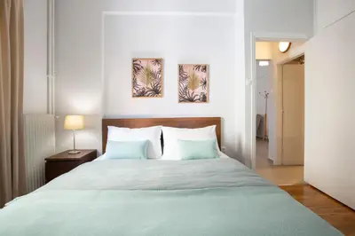 a bedroom with a bed and two paintings on the wall at Apollon Apartment and Museum Acropolis in Athens