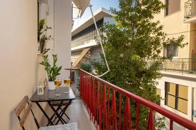 a balcony with a table with two glasses of wine at Apollon Apartment and Museum Acropolis in Athens
